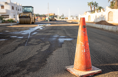 Close up of an orange traffic cone on the road.